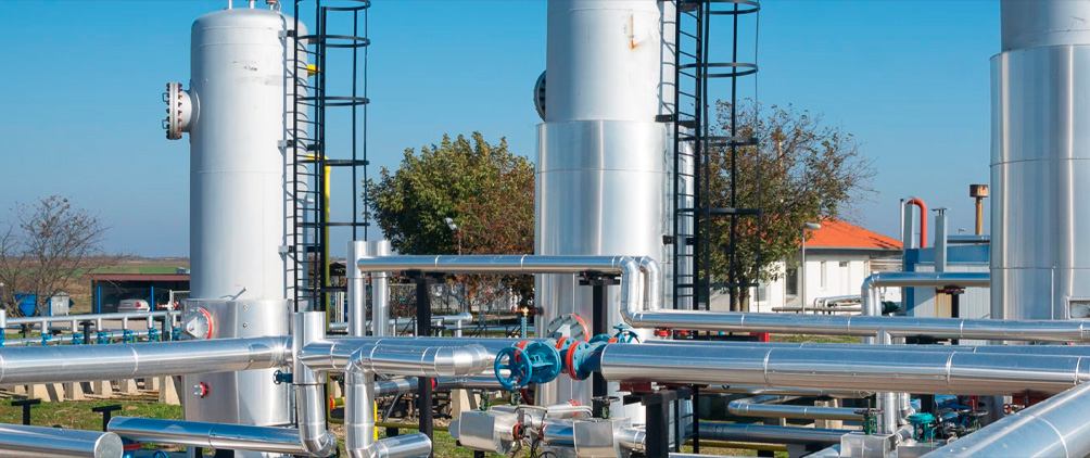 Midstream energy infrastructure with pipelines, storage tanks and processing equipment representing natural gas, LNG and energy transportation assets.