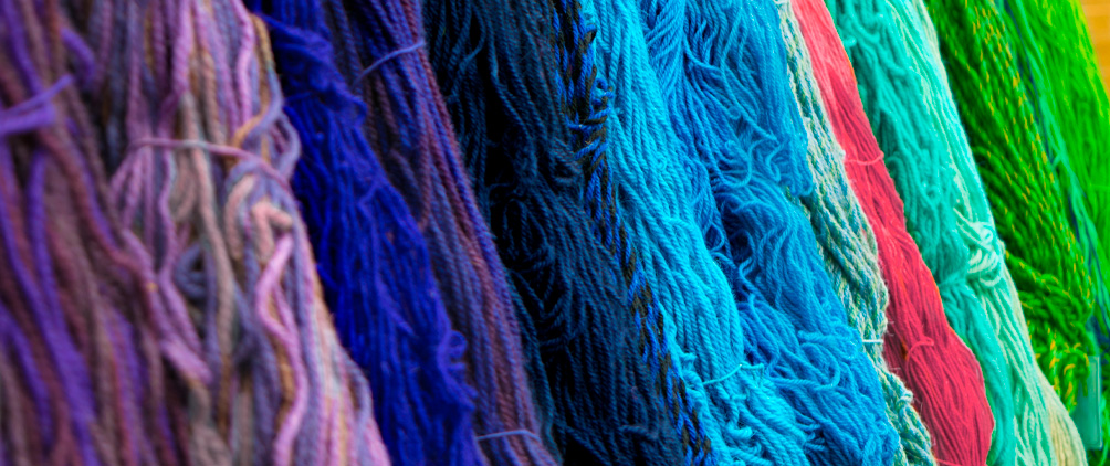 Colorful woven threads representing the diversification, flexibility and portfolio construction benefits of emerging market debt.