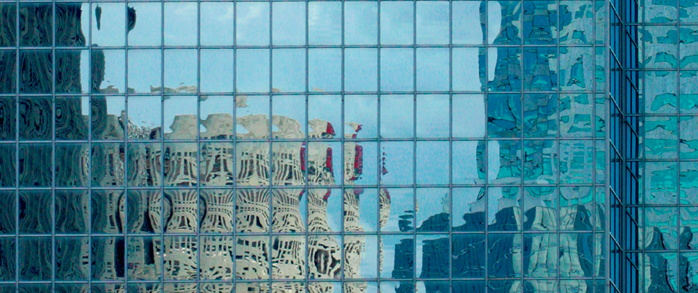 Reflections of surrounding buildings across a grid of glass windows.