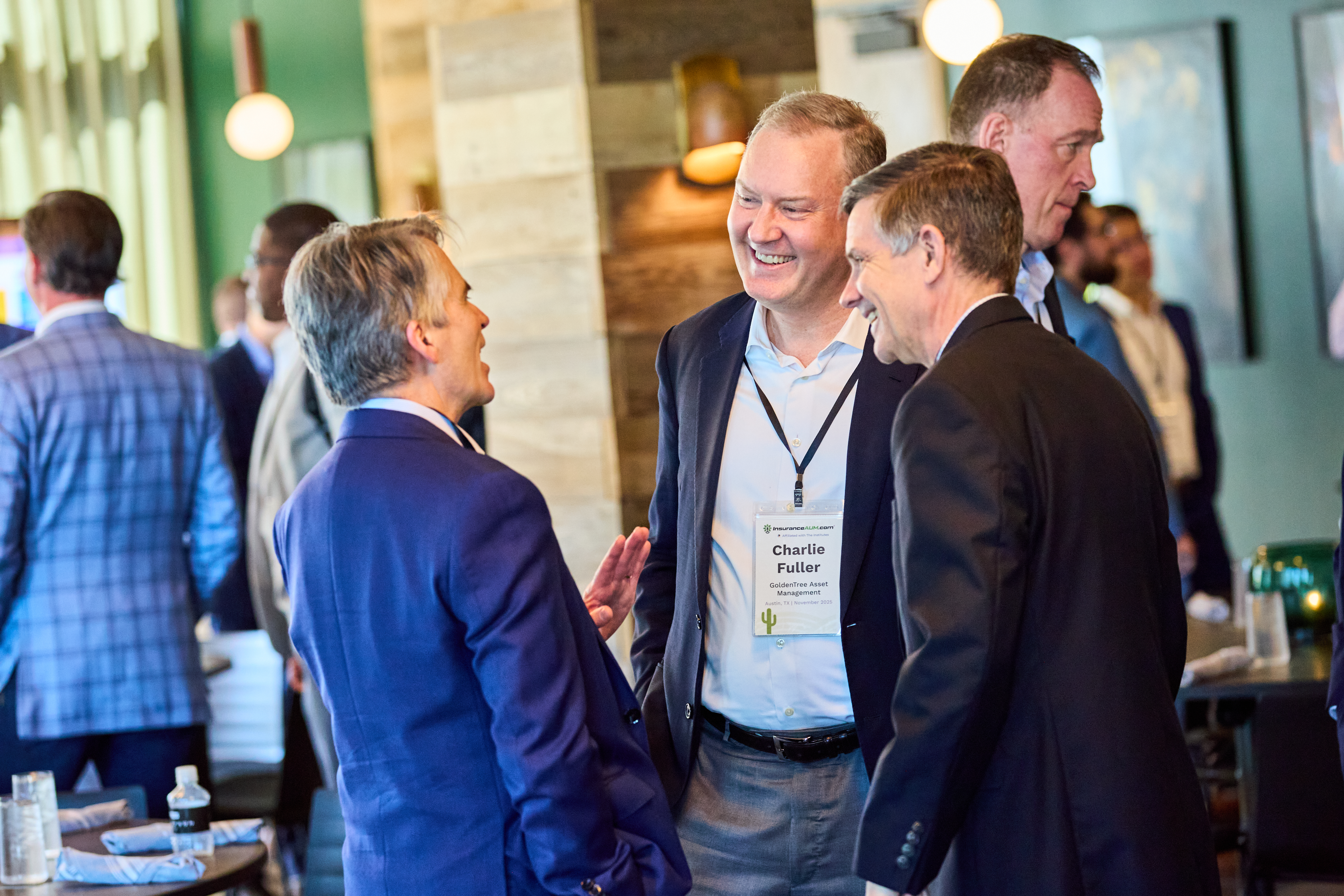 3 event attendees are having a conversation and smiling