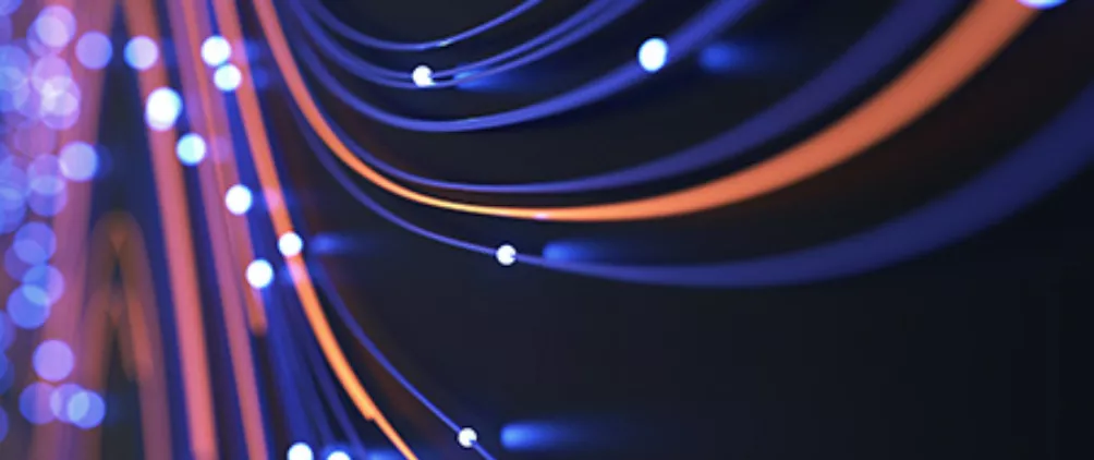 Abstract close-up of illuminated blue and orange fiber optic cables symbolizing data transmission and high-speed internet connectivity.