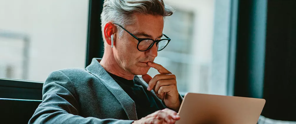 Man reviewing a tablet near a window representing institutional ETF research and asset owner investment trends.
